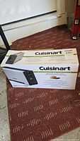 View of the sealed box showing the Cuisinart long-slot toaster packaging and branding.