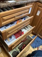 Kitchen drawers containing assorted kitchen utensils, gadgets, bakeware and flatware.