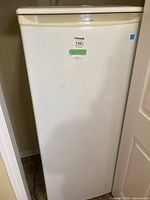 Front view of the white upright freezer with MaxSold sticker showing item number.