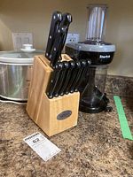Photo showing Ginsu knife set in wooden block, Starfrit spiralizer, and Hamilton Beach crock pot on kitchen counter.
