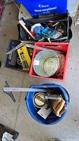 View of all containers showing assorted hand tools including handsaw, putty knife, and metal bucket.