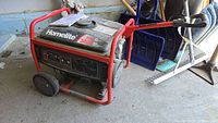 Homelite portable generator in red tubular steel frame with black engine housing and two wheels