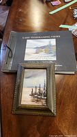 Photo showing the Lake Temiskaming Views book and framed print on a wooden table.