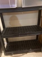 Clear view of the two shelves showing the grid slatted design and black plastic material.
