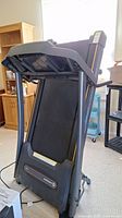 Folded Horizon CT5.0 treadmill showing running belt and console area, power cord on floor