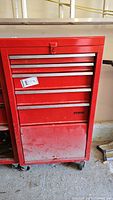 Front view showing five-drawer tool chest, red metal finish, silver handles, caster wheels.
