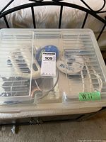 Plastic container holding the Nintendo Wii console and accessories inside with label.