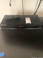 Front view of Sony Blu-ray DVD player with remote on top and auction tag