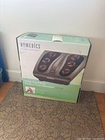 Front view of original packaged Homedics deep kneading Shiatsu foot massager showing brand, model, and product image with visible heating nodes.