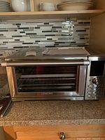 Front view of Nuwave Bravo XL smart oven on a countertop with quick start guide on top.