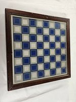 Framed glass chessboard with blue and white squares arranged in a checkerboard pattern