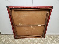 Bottom view of the folding card table showing the wooden support structure.
