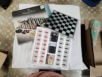 Top view showing box, glass chessboard with chess pieces as shot glasses, and checkers/backgammon board with pieces.