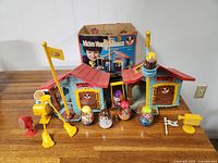 Full view of Mickey Mouse Clubhouse set with figures and accessories on table showcasing the playset and original box background