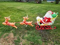 Santa sleigh and two reindeer blow molds arranged on grassy lawn