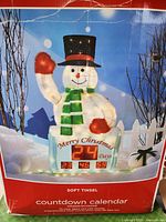 Photo of the soft tinsel snowman countdown calendar outdoor decoration in packaging showing digital countdown and winter design.