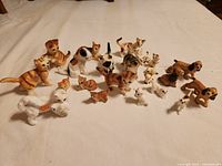 Group of various porcelain cat and dog figurines on white surface
