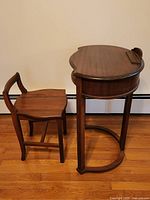 Side view of the wooden telephone table and matching chair on a hardwood floor.