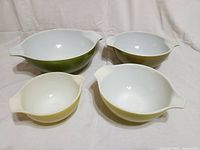 Four vintage Pyrex bowls placed individually and showing color and design details