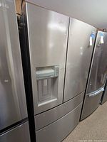 Front view of stainless steel French door refrigerator with bottom freezer drawer and ice/water dispenser