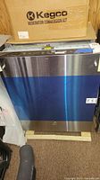 Front view showing stainless steel and blue protective film on the GE dishwasher.