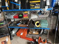 Full view of half-height shelving unit with various items for scale, shelving units made of stainless steel wire grid with caster wheels.