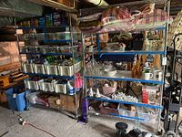 Two 5-tier chrome wire shelving units loaded with contents in basement