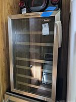 Full view of Danby wine fridge showing glass door with stainless steel trim and wooden shelves inside.