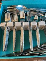 Close-up of forks showing detailed textured handles and tines.