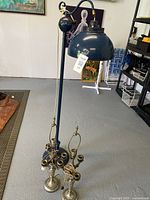 Full view of the floor lamp with metal shade and two brass table lamps in front