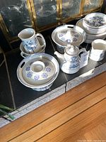 Main grouping: creamer, covered casserole dish, teapot, pitchers and stacked plates.