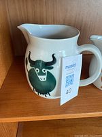 Closer image of tall jug with green bull design, showing detail clearly.