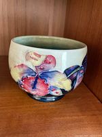Cream colored Moorcroft bowl with multi-colored floral decoration showing glaze crazing