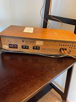 Rear view showing wooden cabinet, input/output ports, and wiring connections for the Panasonic RE 7671.