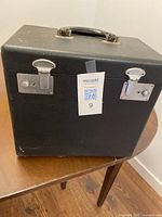 Closed black carrying case on wooden table