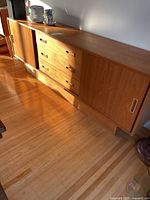 Full view of teak sideboard showing sliding doors and drawers