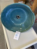 Top view of a green glazed pottery vessel sink, showing the circular shape and central drain.