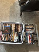 Full view of three containers filled with assorted DVDs and Blu-rays, showing many titles stacked and lined up.