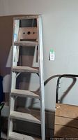 Front full view of the aluminum ladder showing six steps with a top platform and paint can holder.