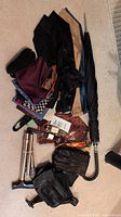 Photo shows assorted men's accessories including ties, gloves, an umbrella, and watches grouped on floor.