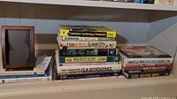 Wooden frame and multiple gardening and reference books stacked on a shelf.