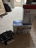 Hamilton Beach toaster in box, Master Chef kettle in box, Prescott CD alarm clock radio on carpet floor