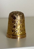 Front view showing detailed floral engraving on thimble body