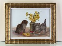 Frontal view of framed oil on glass painting with two kittens and daffodils, apple visible for scale