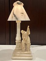 Front view of entire lamp with shade, column, and carved figure