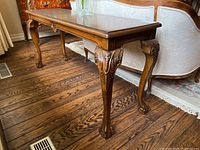 Side view of the walnut hall table showing overall shape and carved cabriole legs