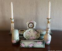 Full set of antique hand painted floral porcelain vanity items including clock, candle holders, trinket boxes, perfume bottle, decorative dish, rectangular box, and tray