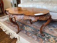 Angled front view of table showing carved apron and cabriole legs