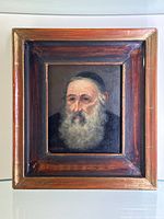 Full view of framed oil painting showing the portrait of a bearded Jewish man or Rabbi in a wooden frame.