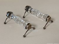 Pair of utensil rests at an angle showing overall shape and support structure